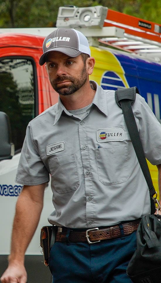 Fuller technician Jessie walking with a tool bag beside a colorful company service van.