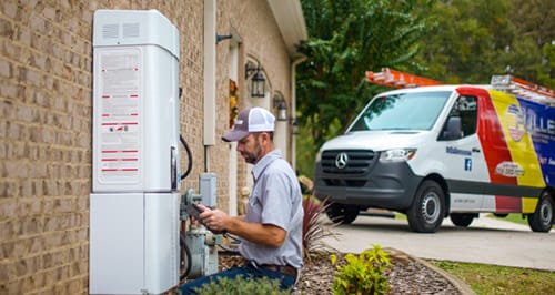 Technician performing outdoor HVAC system maintenance with a Fuller service van in the driveway.