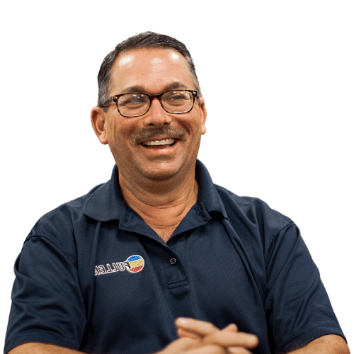 Smiling Fuller team member wearing a branded polo during an indoor meeting.