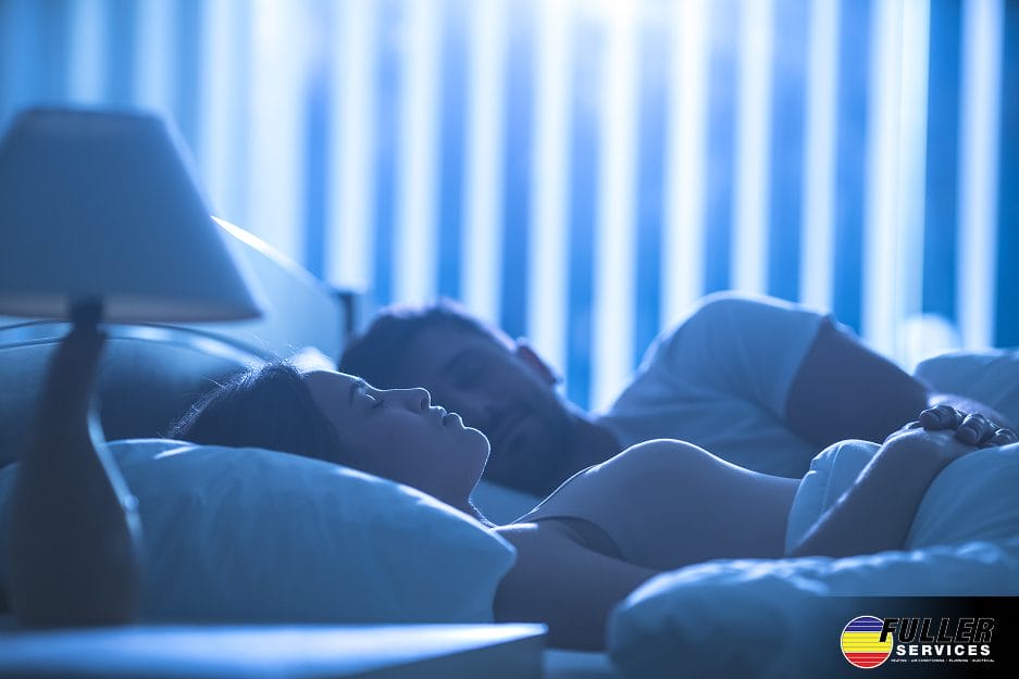 Couple sleeping comfortably at night with optimal room temperature for better sleep and energy savings.